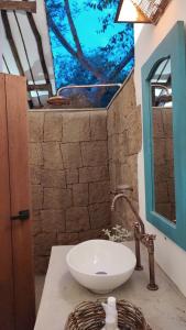 La salle de bains est pourvue d'un lavabo blanc et d'un miroir. dans l'établissement Estancia Arboreto - Reserva Natural, à Barichara