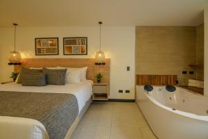 1 dormitorio con cama y bañera en First Class Hotel by 5 Host, en Medellín
