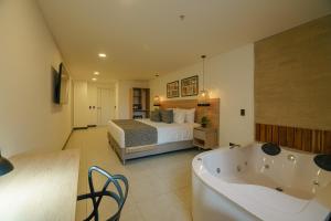 a bedroom with a bed and a tub in a room at First Class Hotel in Medellín