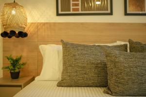 a bedroom with a bed with pillows and a lamp at First Class Hotel in Medellín