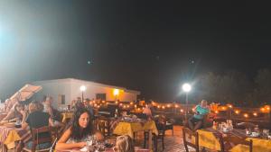 a group of people sitting at tables at night at Agriturismo Paulesa in Cala Gonone