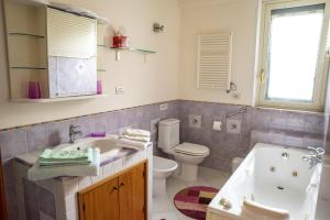 a bathroom with a tub and a toilet and a sink at Casa Limoncello in Taormina +11 photos