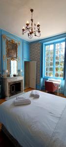 貝萊姆的住宿－Chateau de la Grand'Maison，卧室配有白色大床和蓝色的墙壁