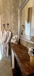 a bathroom with a counter with a mirror and towels at Chateau de la Grand'Maison in Bellême