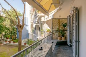 einen Balkon mit einem Tisch und einem Baum in der Unterkunft Secret Garden Downtown in Athen