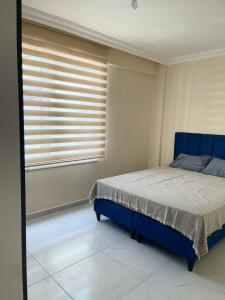 um quarto com uma cama azul e uma janela em White house em Alanya