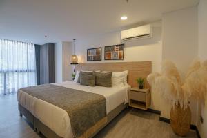a bedroom with a large bed and a large window at First Class Hotel in Medellín