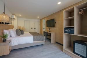 a hotel room with a bed and a desk and a tv at First Class Hotel in Medellín