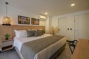 a bedroom with a large bed and a table at First Class Hotel in Medellín