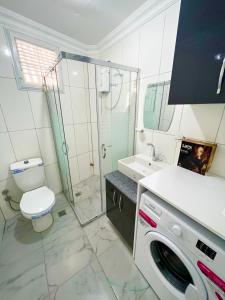 uma casa de banho com um WC e uma máquina de lavar roupa em White house em Alanya