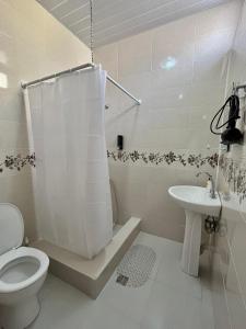 biała łazienka z toaletą i umywalką w obiekcie Elegance w mieście Sighnaghi