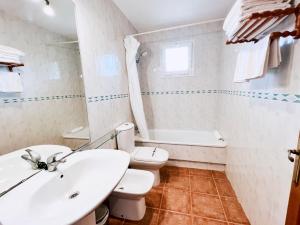 a white bathroom with a sink and a toilet at Apart. en Jardín del Golf in Chiclana de la Frontera
