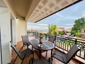 a patio with a table and chairs on a balcony at Almyriki Apartment in Ierissos