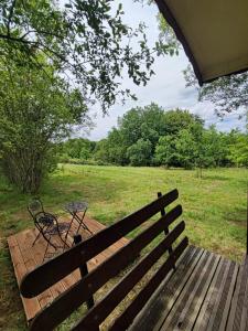 a wooden bench with a table in a field at La roulotte Couzotte in Couze-et-Saint-Front