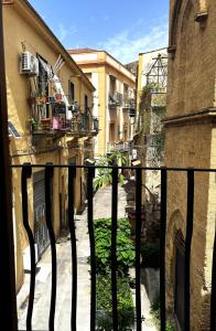 a view of an alley with a fence and buildings at Sette Fate Suites Spa in Palermo