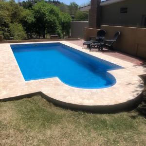 a swimming pool with blue water in a backyard at Casa La Quinta in Villa Carlos Paz
