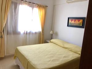 a bedroom with a bed and a window with a curtain at Casa La Quinta in Villa Carlos Paz +9 photos