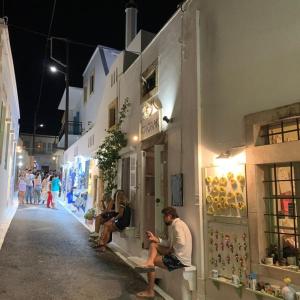 a group of people sitting on a bench in a street at Hytra view house in Kythira +10 photos