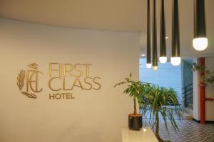 a first la class hotel sign on a wall with plants at First Class Hotel in Medellín