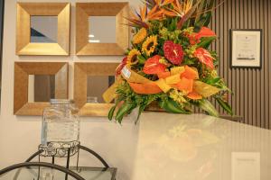 a bouquet of flowers sitting on a table with a vase at First Class Hotel in Medellín