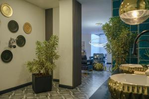 a lobby with potted plants and a sink and a table at First Class Hotel in Medellín