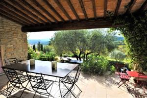 a table and chairs on a patio with a view at In Gordes, facing the entire Luberon Park a beautiful 5 bedrooms house in Gordes