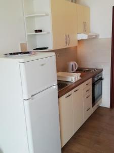 a kitchen with a white refrigerator and a stove at APARTMANI JURIĆ in Trpanj