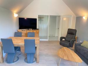 a living room with a table and chairs and a television at Bernsteinfischer - Fewo mit 2 Balkone in Zempin