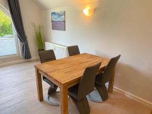 a wooden table and chairs in a dining room at Bernsteinfischer - Fewo mit 2 Balkone in Zempin +31 photos
