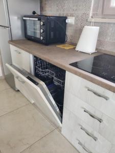 a kitchen with a black microwave on a counter at Villa Terrazza sul Golfo in Monte SantʼAngelo