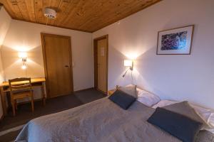 een slaapkamer met een bed en een bureau bij Lemonsjø Fjellstue og Hyttegrend in Randsverk