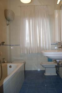 La salle de bains est pourvue d'un lavabo, de toilettes et d'une baignoire. dans l'établissement Grande villa a 100 m. dal mare, à San Felice Circeo