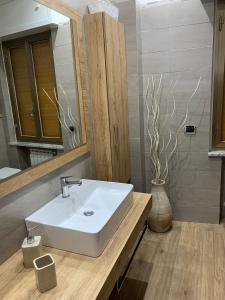 La salle de bains est pourvue d'un lavabo blanc et d'un miroir. dans l'établissement Casa vacanze, à Soverato Marina