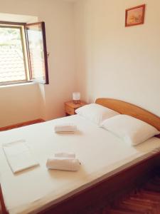 a bedroom with a bed with two towels on it at APARTMANI JURIĆ in Trpanj