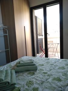 a bedroom with a bed with green towels on it at Biancaura sunlight in Comiso