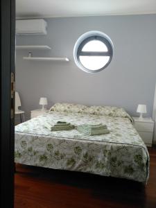 コーミゾにあるBiancaura sunlightのベッドルーム1室(ベッド1台、丸窓付)
