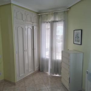 een kamer met een witte kast en een raam bij VILLA LIA in Vinarós