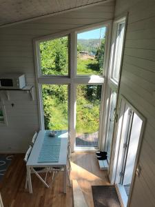 een kamer met een tafel en een groot raam bij Åsarna Hills Holiday Home Stillingsön in Stillingsön