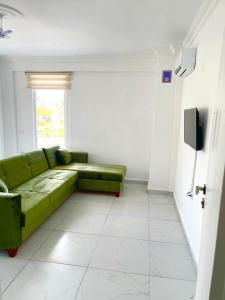 uma sala de estar com um sofá verde e uma janela em White house em Alanya