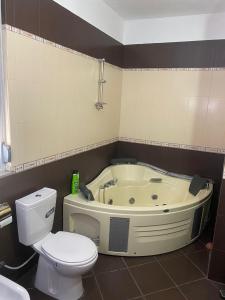 uma casa de banho com um WC e uma banheira em Cactus Coastal: 3-Bedroom Condo II em Vlorë