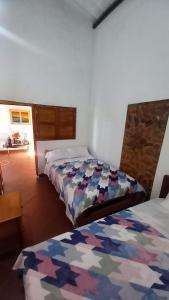 a room with two beds in a room at Hostal posada San jose in San José de Suaita