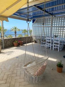 um baloiço num pátio com uma mesa e cadeiras em Cactus Coastal: 3-Bedroom Condo II em Vlorë