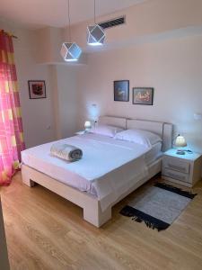 um quarto com uma grande cama branca e duas mesas de cabeceira em Cactus Coastal: 3-Bedroom Condo II em Vlorë