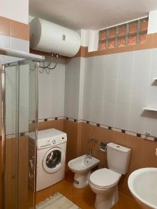 uma casa de banho com um lavatório e uma máquina de lavar roupa em Cactus Coastal: 3-Bedroom Condo II em Vlorë