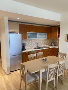 uma cozinha com uma mesa com cadeiras e um frigorífico em Cactus Coastal: 3-Bedroom Condo II em Vlorë