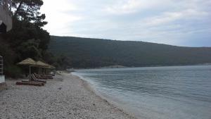 a beach with chairs and umbrellas next to the water at HAPPY VIEW Appartement in Kruče