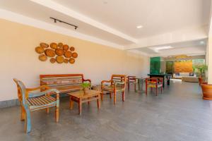 - une salle d'attente avec des chaises, des tables et une table dans l'établissement Miola Hotel, à Porto Seguro