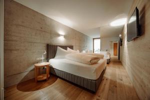 a bedroom with two beds and a tv on a wall at Appartement Schwarz in Sankt Johann im Pongau