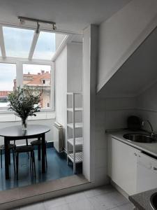 una pequeña cocina con mesa y ventana en Ático luminoso con terraza, en Santander
