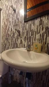 y baño con lavabo blanco y espejo. en Hostal posada San jose, en San José de Suaita